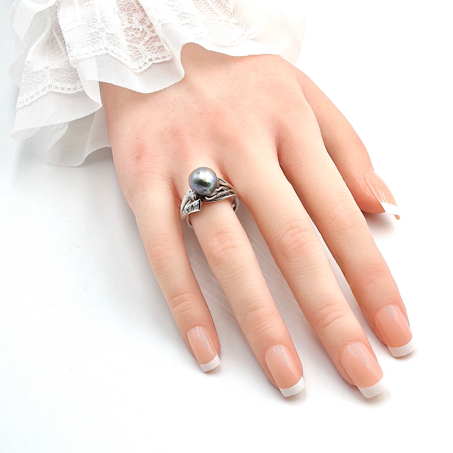 Ring in 590 white gold with a cultured pearl and diamonds, on the hand