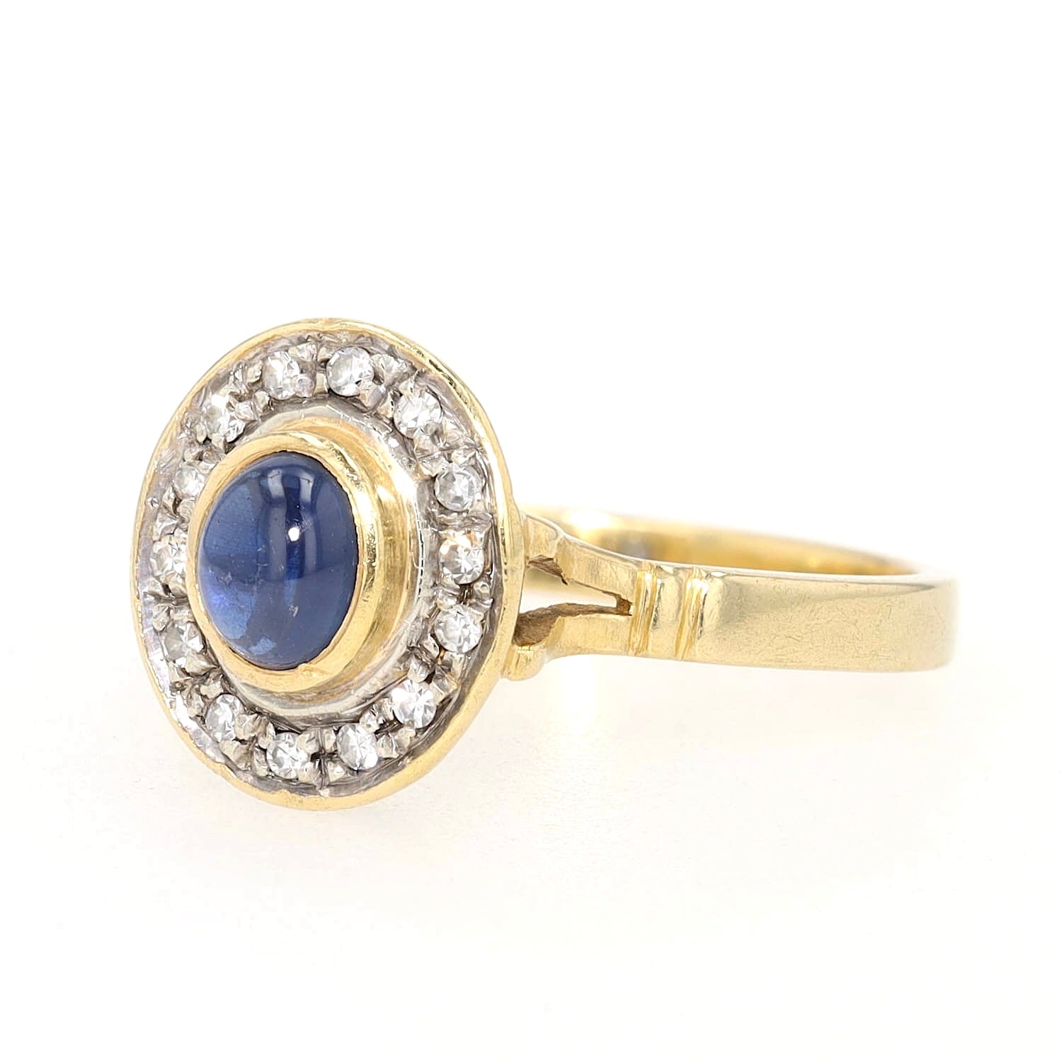 Ring in 750 yellow gold with a blue sapphire cabochon and diamonds, turned horizontally to the left