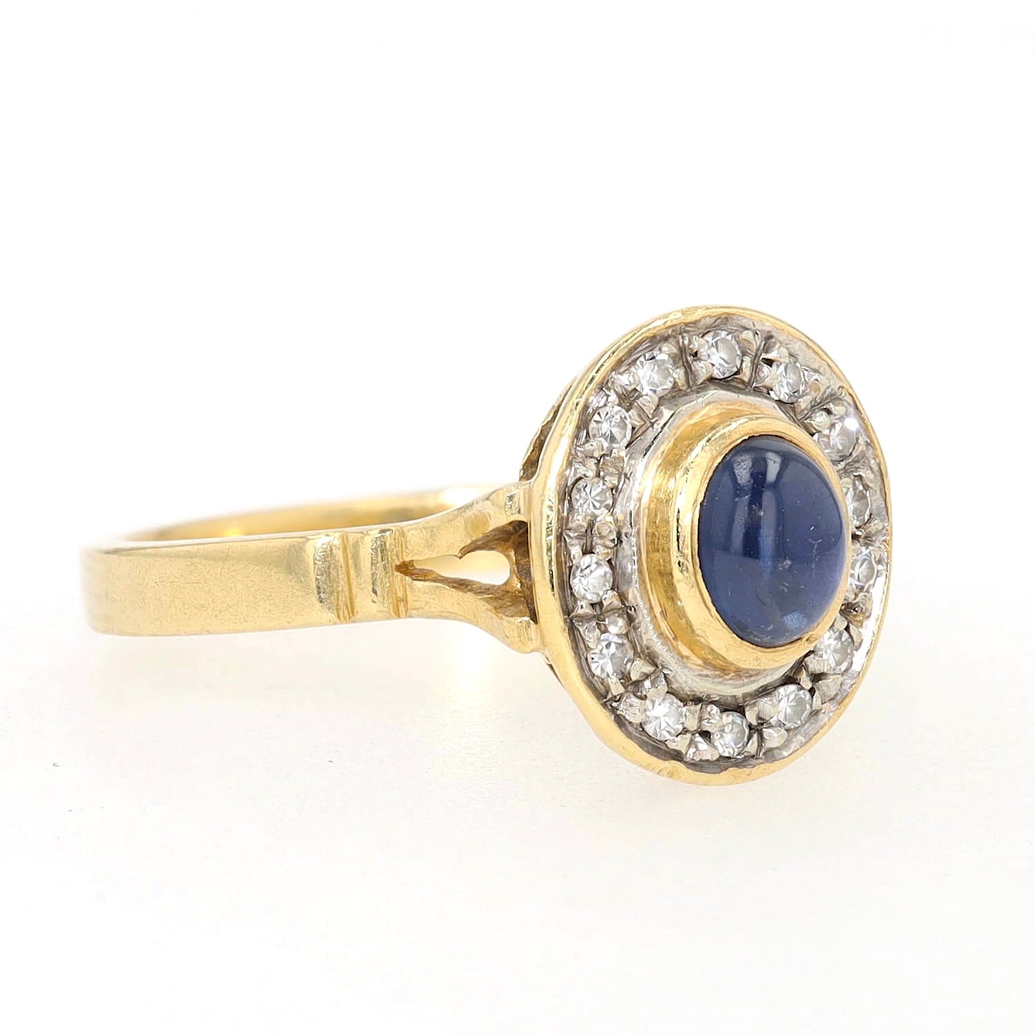 Ring in 750 yellow gold with a blue sapphire cabochon and diamonds, turned horizontally to the right