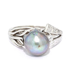 Ring in 590 white gold with a cultured pearl and diamonds, lying frontally