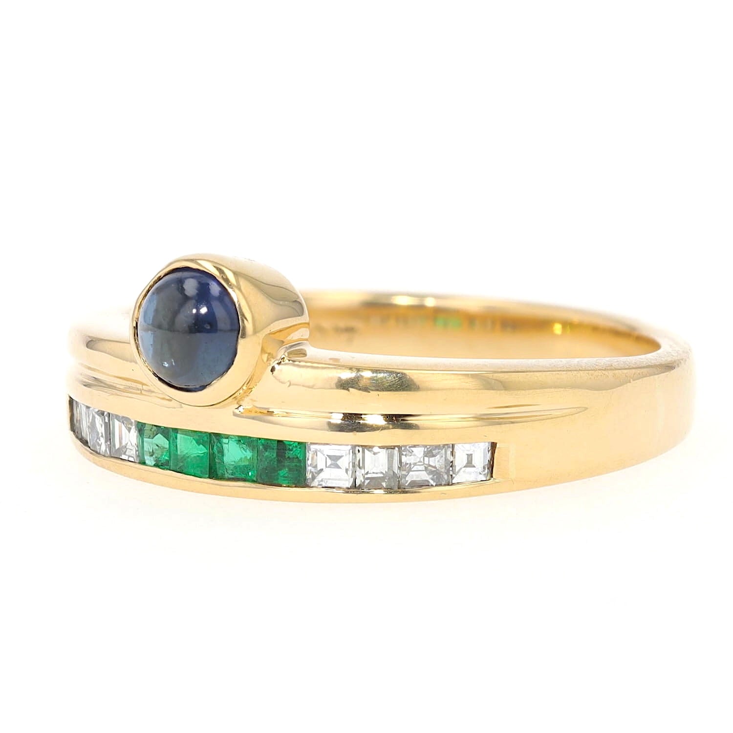 Buchwald ring in 750 yellow gold with diamonds, emeralds and a sapphire cabochon, turned horizontally to the left