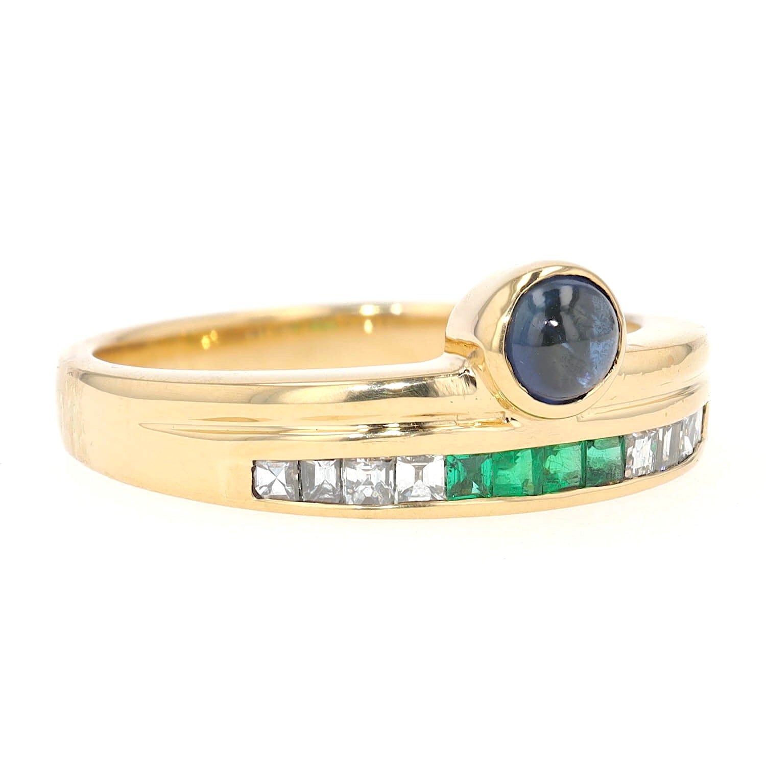 Buchwald ring in 750 yellow gold with diamonds, emeralds and a sapphire cabochon, turned horizontally to the right