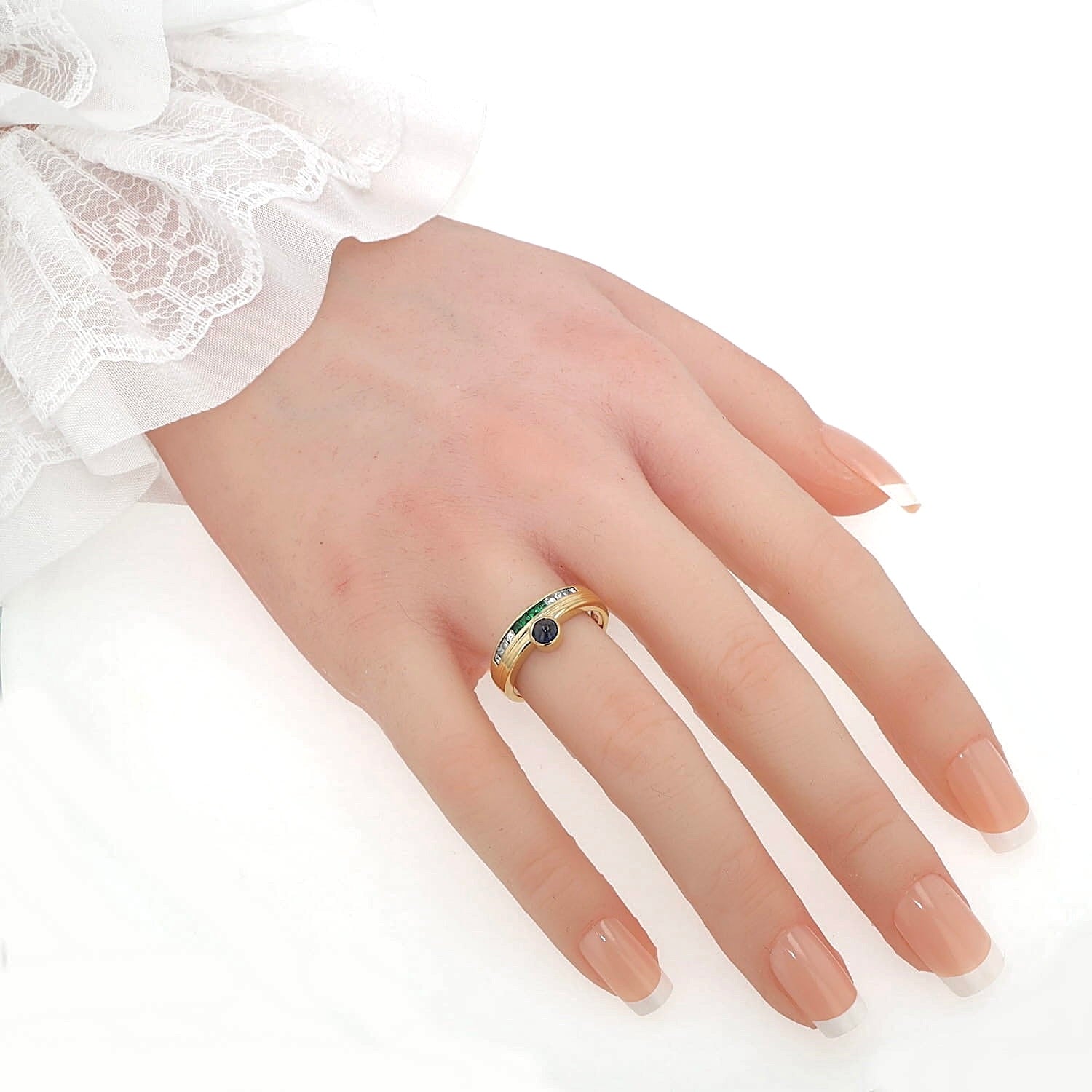 Buchwald ring in 750 yellow gold with diamonds, emeralds and a sapphire cabochon, on the hand