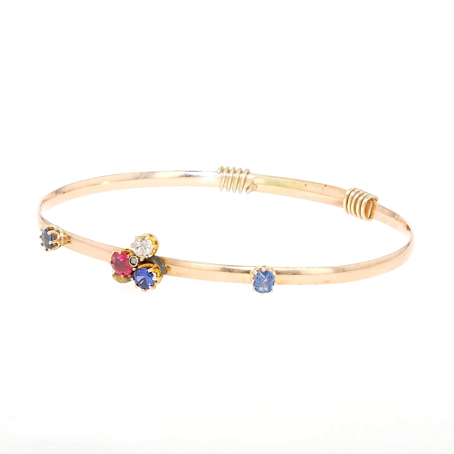 Vintage bangle in 585 rose gold with diamonds, a red spinel and sapphires, turned horizontally to the left