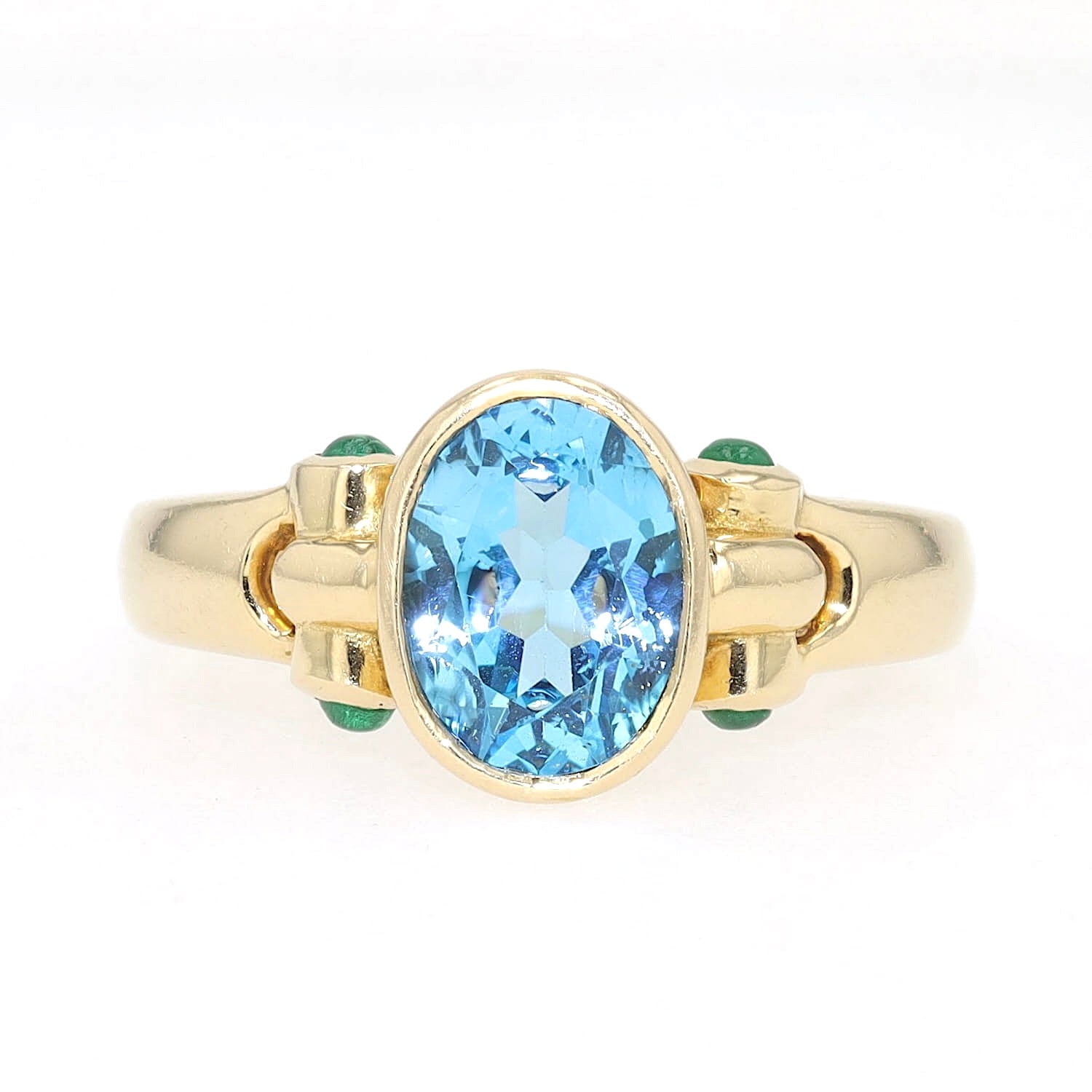 Ring in 750 yellow gold with a blue topaz and emeralds, lying frontally