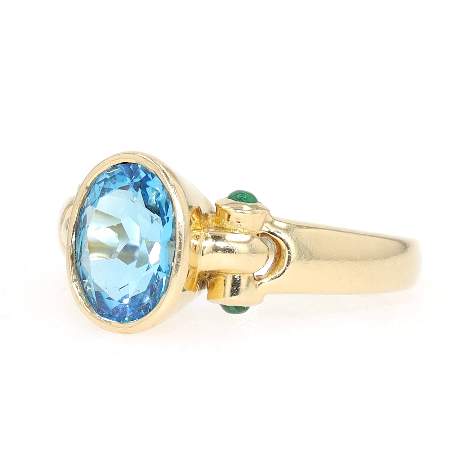 Ring in 750 yellow gold with a blue topaz and emeralds, turned horizontally to the left