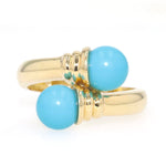 Ring in 585 yellow gold with two turquoise spheres, lying frontally