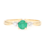 Ring in 585 yellow gold with an emerald and brilliants, lying frontally