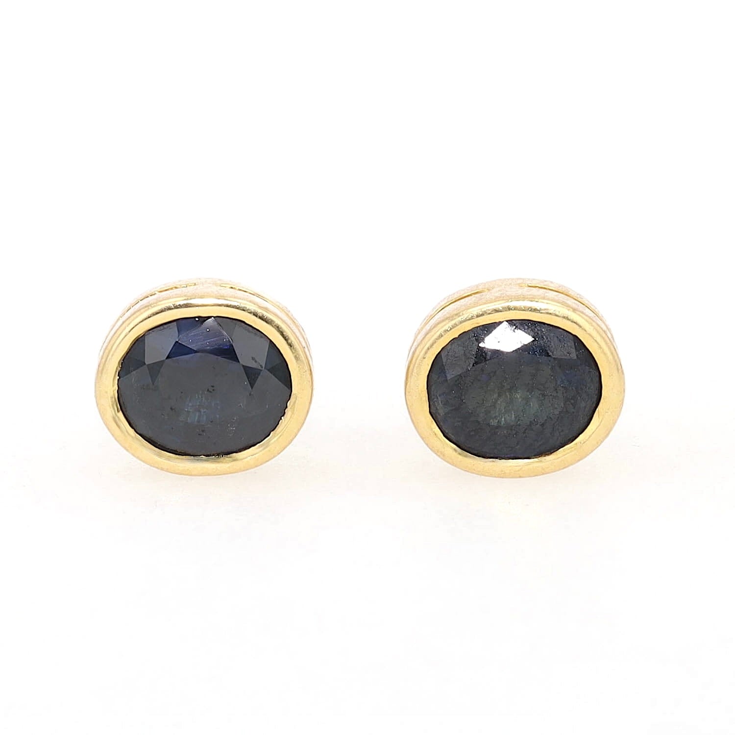 Pair of vintage ear studs in 750 yellow gold, each with a sapphire, lying frontally