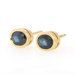 Pair of vintage ear studs in 750 yellow gold, each with a sapphire, turned horizontally to the left