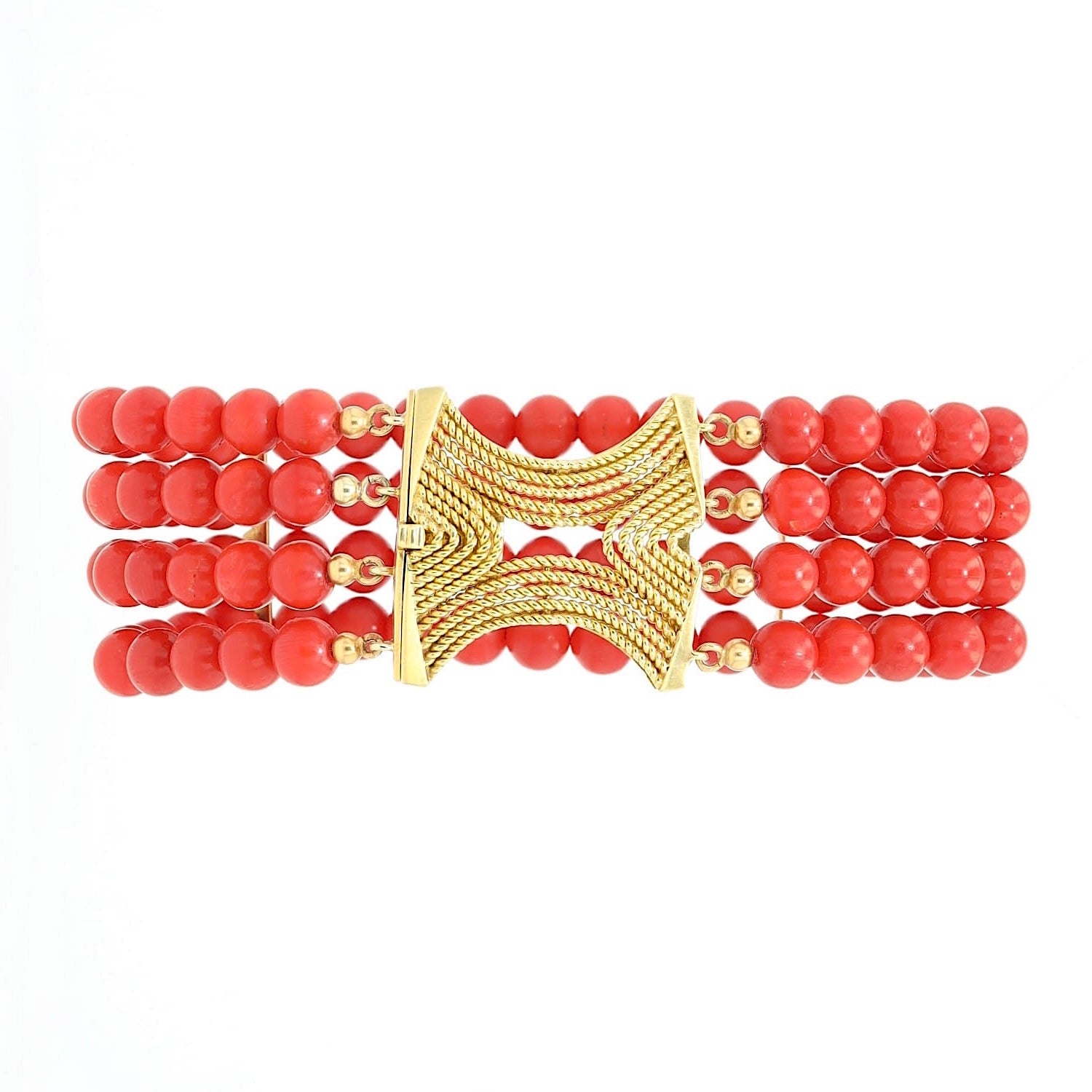 Four-row vintage red coral bracelet with a 750 yellow gold clasp, lying on its side in front